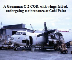 A Grumman C-2 COD, with wings folded, 
undergoing maintenance at Cubi Point